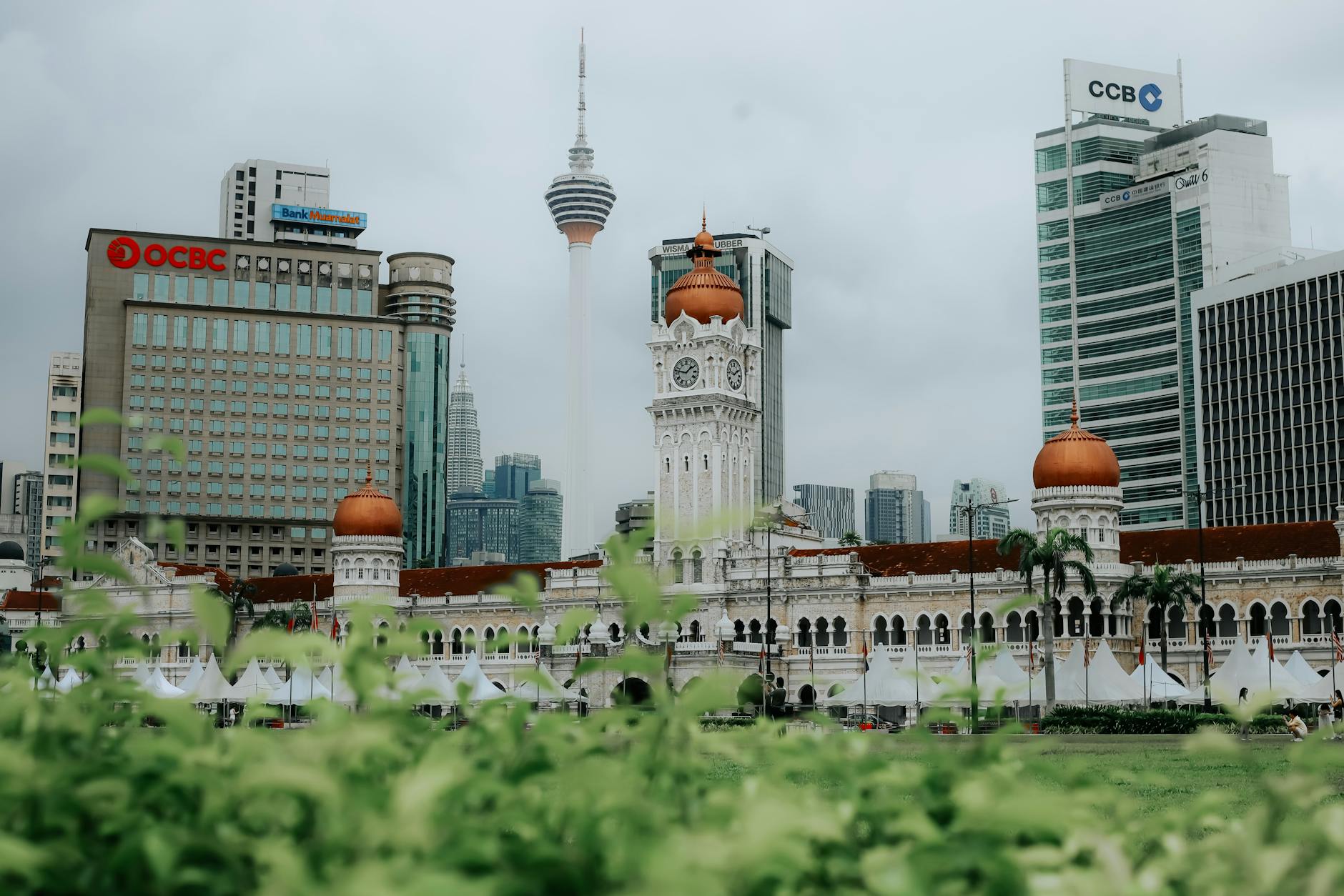 Kuala Lumpur's skyline featuring Merdeka Square and KL Tower on an overcast day.
