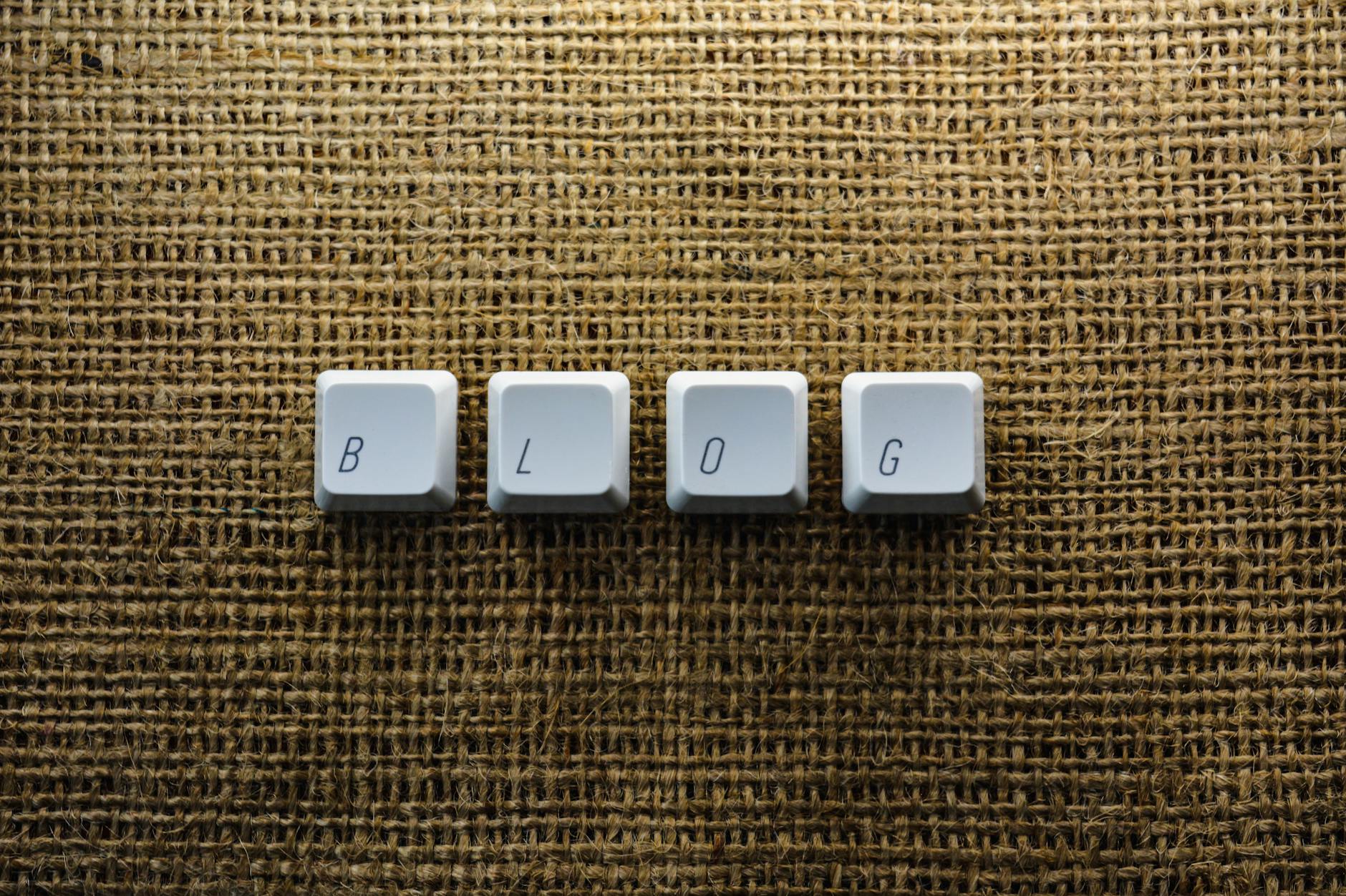 Close-up of keyboard keys spelling 'BLOG' on a burlap surface, ideal for tech blogs.