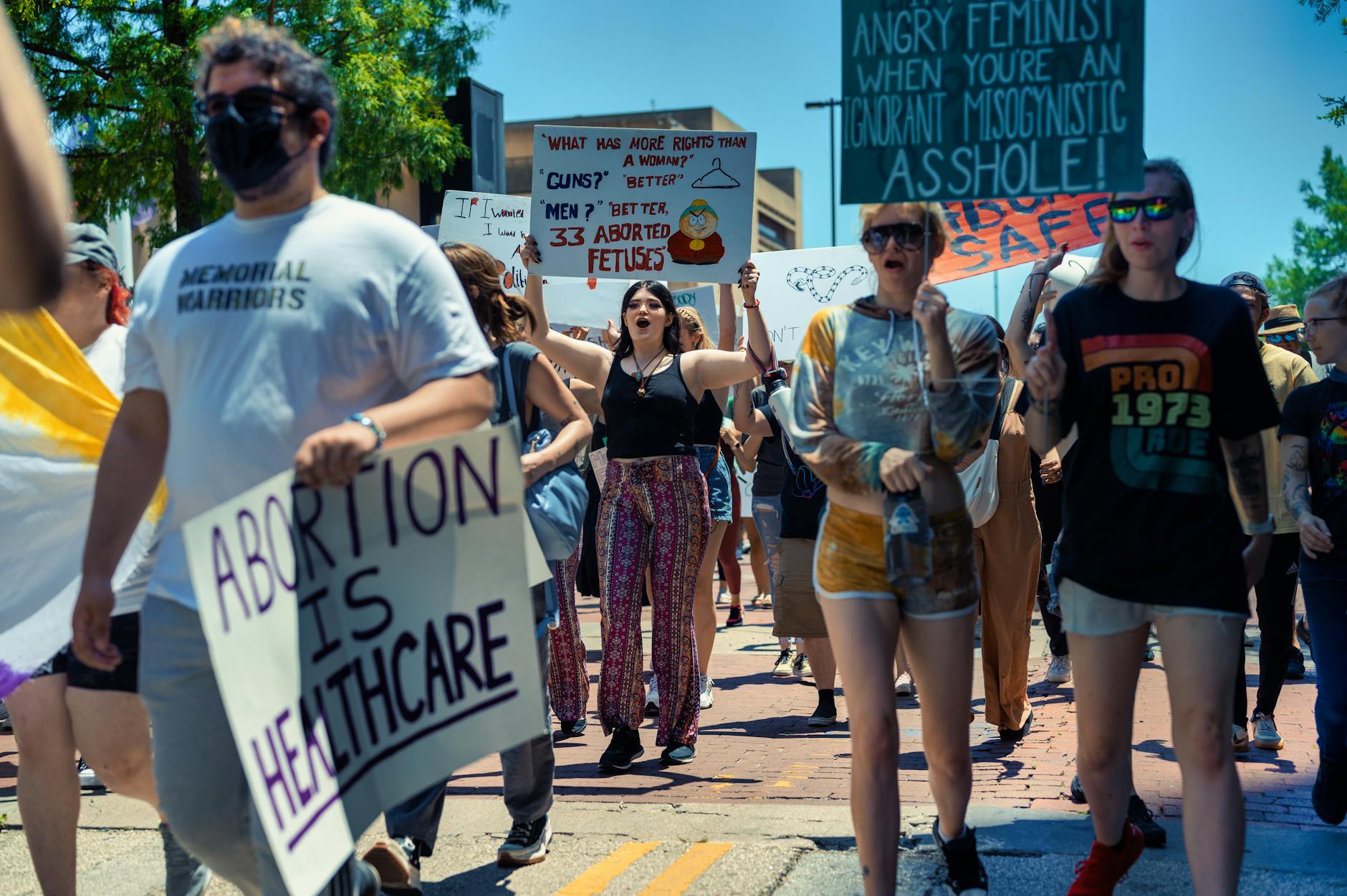 A diverse crowd protesting for women's rights and healthcare access in a peaceful demonstration.