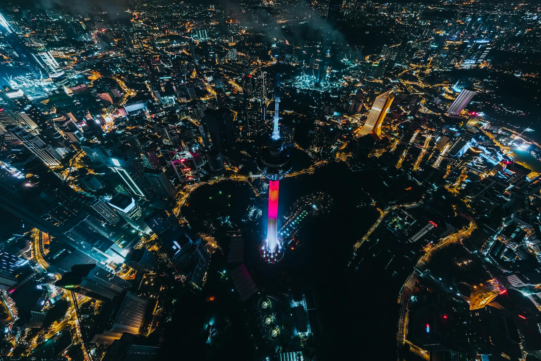 Stunning aerial view of Kuala Lumpur's vibrant cityscape at night, showcasing illuminated landmarks and skyline.